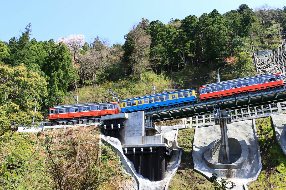 Hakone Tozan Tetsudô, Partnerbahn der RhB: Im steilen Abstieg von Kowakidani nach Miyanoshita überquert der letzte verbliebene Altbauzug die nach dem Taifun von der Nacht 12./13.Oktober 2019 vollständig neu aufgebaute Strecke, 12.April 2022. Die drei noch existierenden Altbauwagen sind 104-106-108. 104 und 106 sind 1950 neu aufgebaute  Originalwagen , 108 stammt von 1927 und hat (oder hatte??) Elektroausrüstung und Drehgestelle aus der Schweiz. 