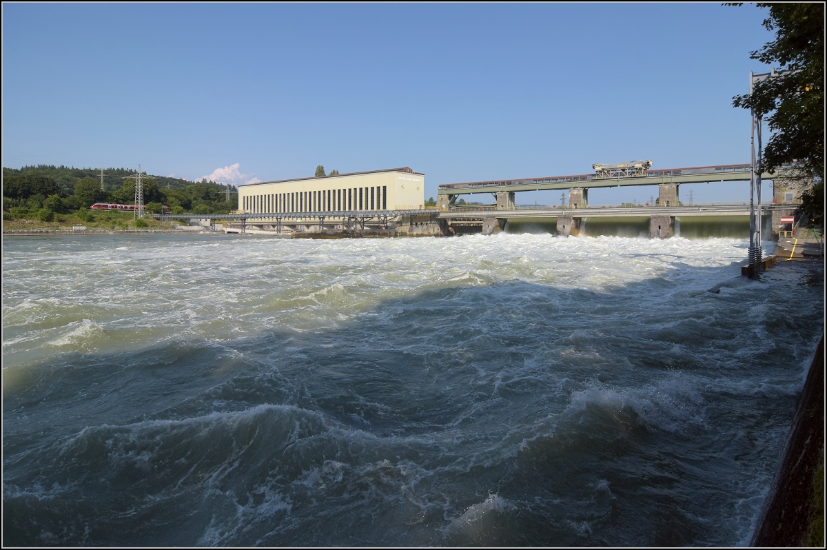 Hochwasser am Hochrhein.

Durch die Flutwehre des Kraftwerk Ryburg-Schwörstadt rauscht mehr Wasser am Kraftwerk vorbei (dürfte ca. 1000 m²/s sein), als am Rheinfall zur gleichen Zeit herunterstürzt. Entsprechend laut ist das Getöse. Trotzdem hört man auch den 644 auf der deutschen Seite ganz deutlich. Möhlin, Juli 2021. 