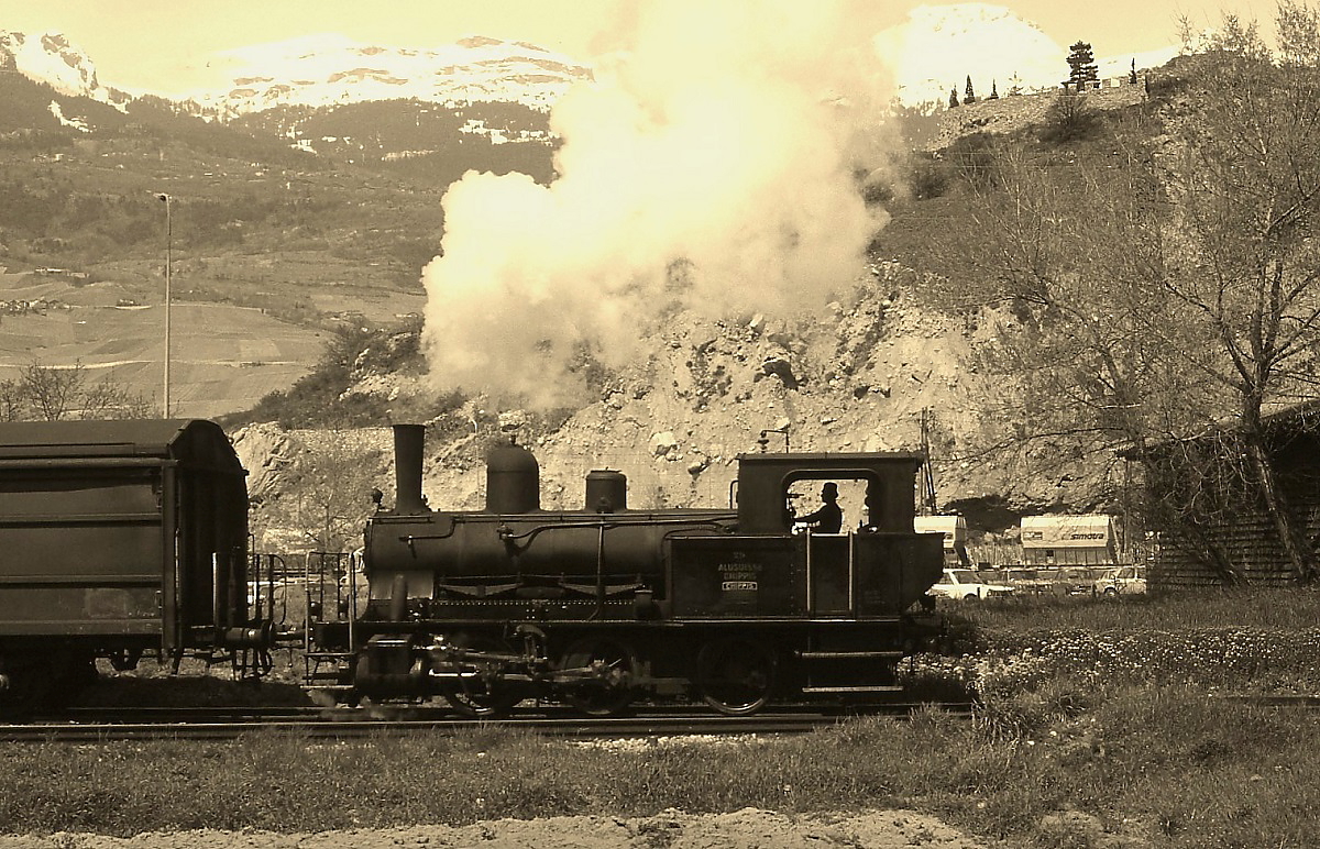 Im Mai 1980 setzte die Alusuisse in Chippis bei Sierre noch die E 3/3 8523  Chippis  (SLM 2503/1915, ex SBB E 3/3 8523) in ihrem Werk ein. Erfreulicherweise verließ sie bei den Rangierarbeiten das Werksgelände und konnte deshalb vor der Kulisse der schneebedeckten Dreitausender aufgenommen werden.