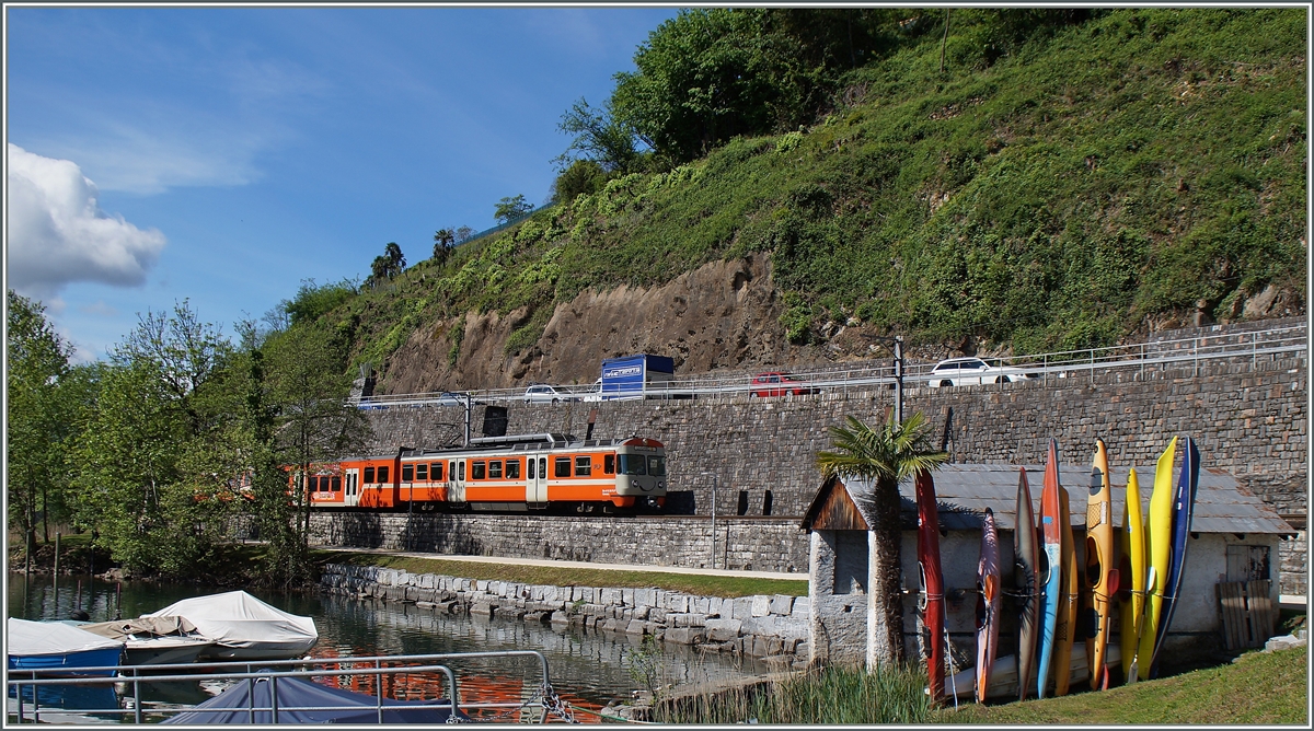 Kurz vor Agno fährt dieser FLP Regionalzug Richtng Lugano an einem Bootshaus mit bunten Kanus vorbei. 
30. April 2015