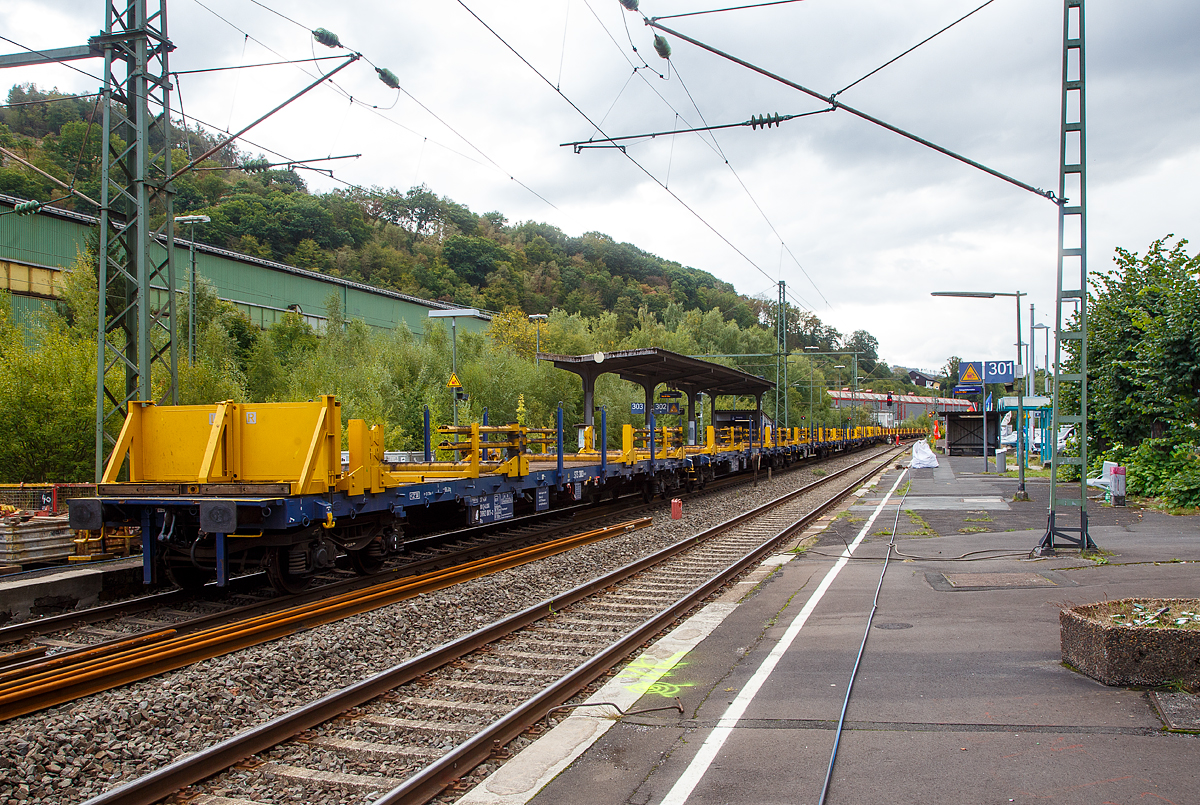 Langschienentransporteinheit STS 3003 (auf 4-achsigen Drehgestell-Flachwagen der Gattung Rs) der Vossloh Rail Service GmbH am 17.09.2022 im Bahnhof Niederschelden (geografisch eigentlich Niederschelderhütte).

TECHNISCHE DATEN je Wagen:
Anzahl der Wagen der Einheit: 6
Spurweite: 1.435 mm
Anzahl der Achsen: 4
Länge über Puffer: 21.700 mm
Drehzapfenabstand: 16.660 mm
Achsabstand im Drehgestell: 1.800 mm
Durchschnittliches Eigengewicht: 6 x 24,4 t/Wg. = 146,4t/Einheit
Breite (zwischen den Rungen): 2.640 mm 
Höhe Fahrzeugboden über SO: 1.230 mm
Höchstgeschwindigkeit: 100 km/h
Kleinster befahrbarer Gleisbogen: unbeladen 75 m, beladen 150 m
Bremse: KE – GP (LL)
Bremssohle: IB 116
Handbremse: nein
Fahrzeugumgrenzungslinie: Lichtraumprofil G1