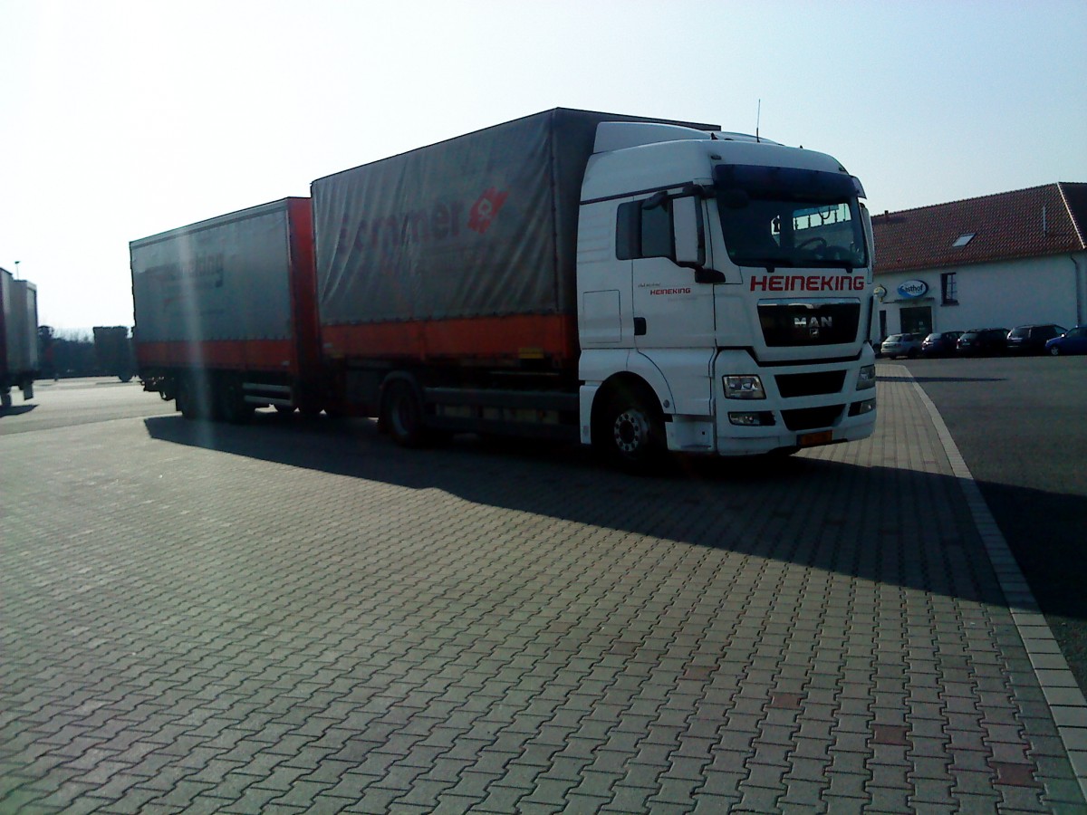 LKW MAN TGX Hngerzug mit Pritsche-Planen-Aufbau der Spedition Heineking gesehen auf dem Autohof in Grnstadt am 12.03.2014