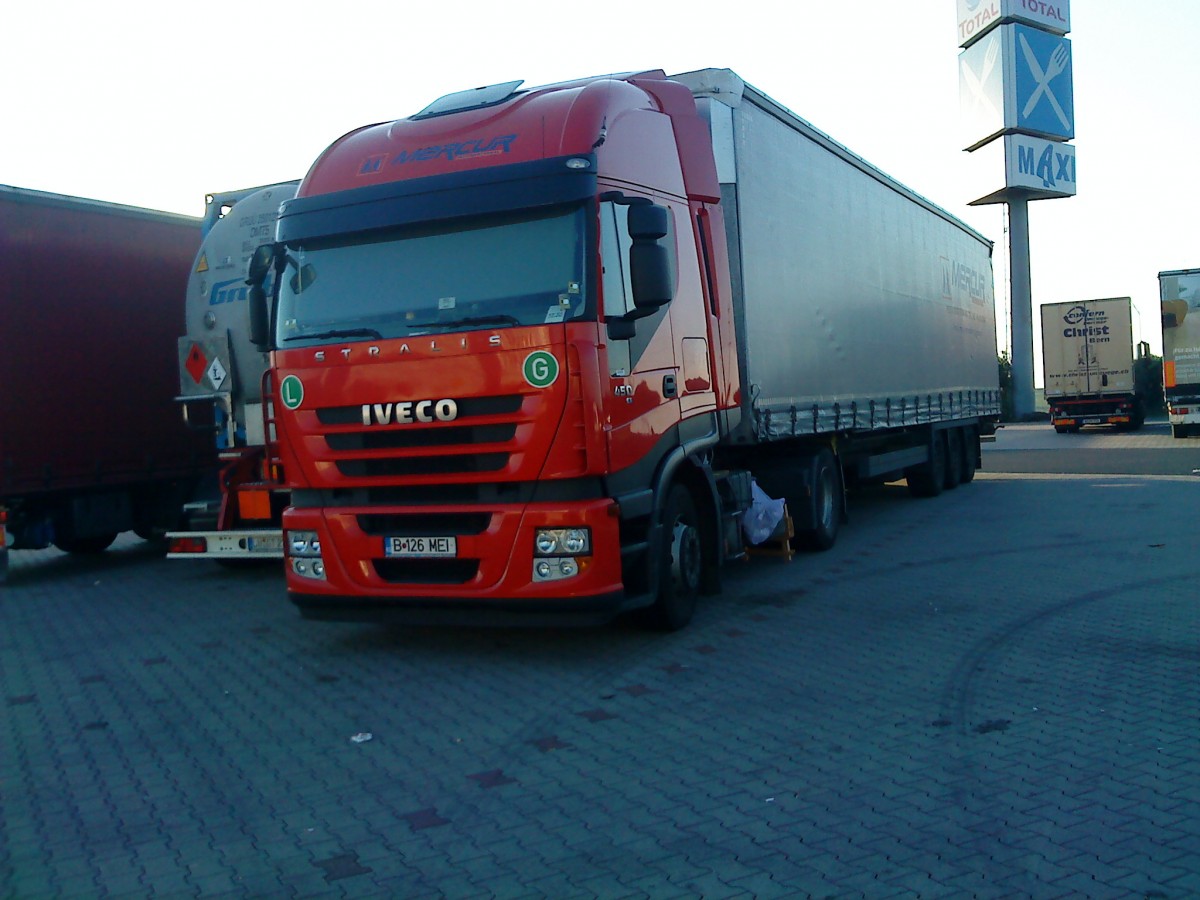 LKW SZM IVECO Stralis 450 mit Pritsche-Planen-Auflieger auf dem Autohof in Grnstadt am 12.09.2013