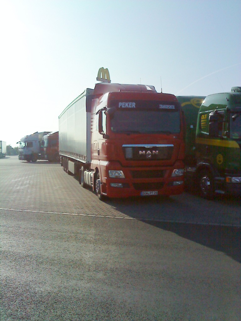 LKW SZM MAN TGX mit Pritsche-Planen-Auflieger der Spedition PEKER auf dem Autohof in Grnstadt am 26.09.2013