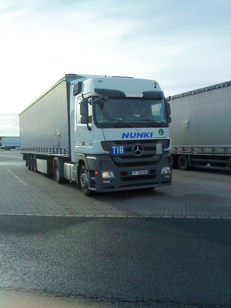 LKW SZM Mercedes-Benz Actros 1844 mit Pritsche-Planen-Auflieger der Spedition NUNKI auf dem Autohof in Grnstadt am 21.10.2013