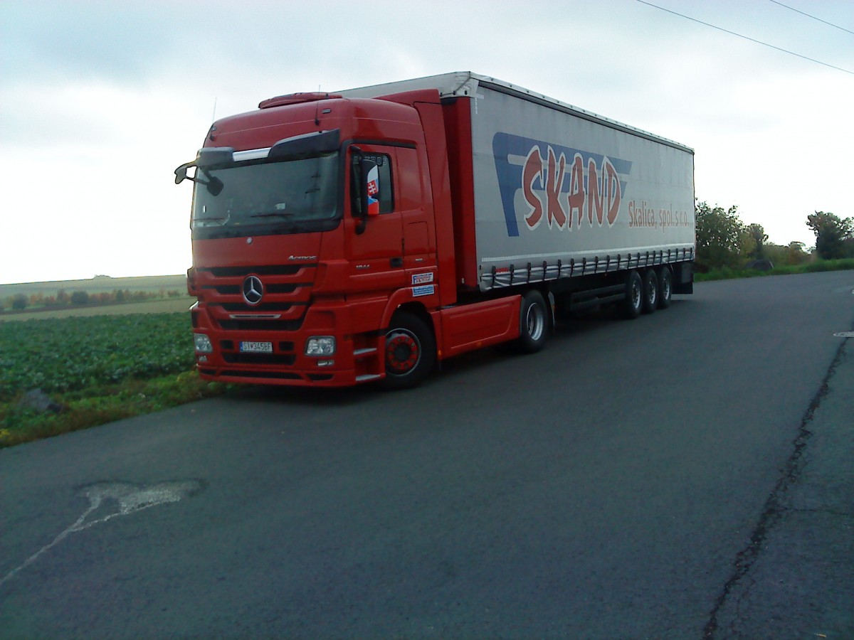 LKW SZM Mercedes-Benz Actros 1844 mit Pritsche-Planen-Auflieger der Spedition SCAND auf dem Autohof in Grnstadt am 23.10.2013