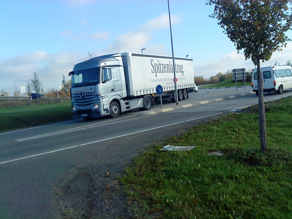 LKW SZM Mercedes-Benz Actros 1846 mit Pritsche-Planen-Auflieger der Firma Charter-way beim Verlassen des Autohofes am 30.10.2013