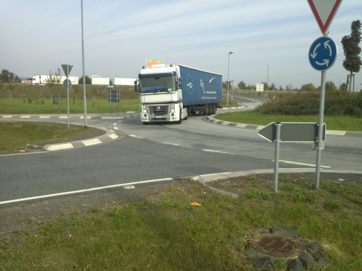 LKW SZM Renault Magnum mit Pritsche-Planen-Auflieger im Kreisel vor dem Autohof in Grnstadt am 01.10.2013