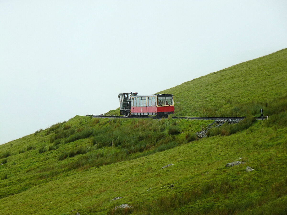 Lok 12 der Snowdon Mountain Railway / Rheilffordd yr Wyddfa (1992) erklimmt mit ihrem relativ neuen Personenwagen (1988) den Berg, vor einer Nebel-Kulisse. 6.Juli 2012   