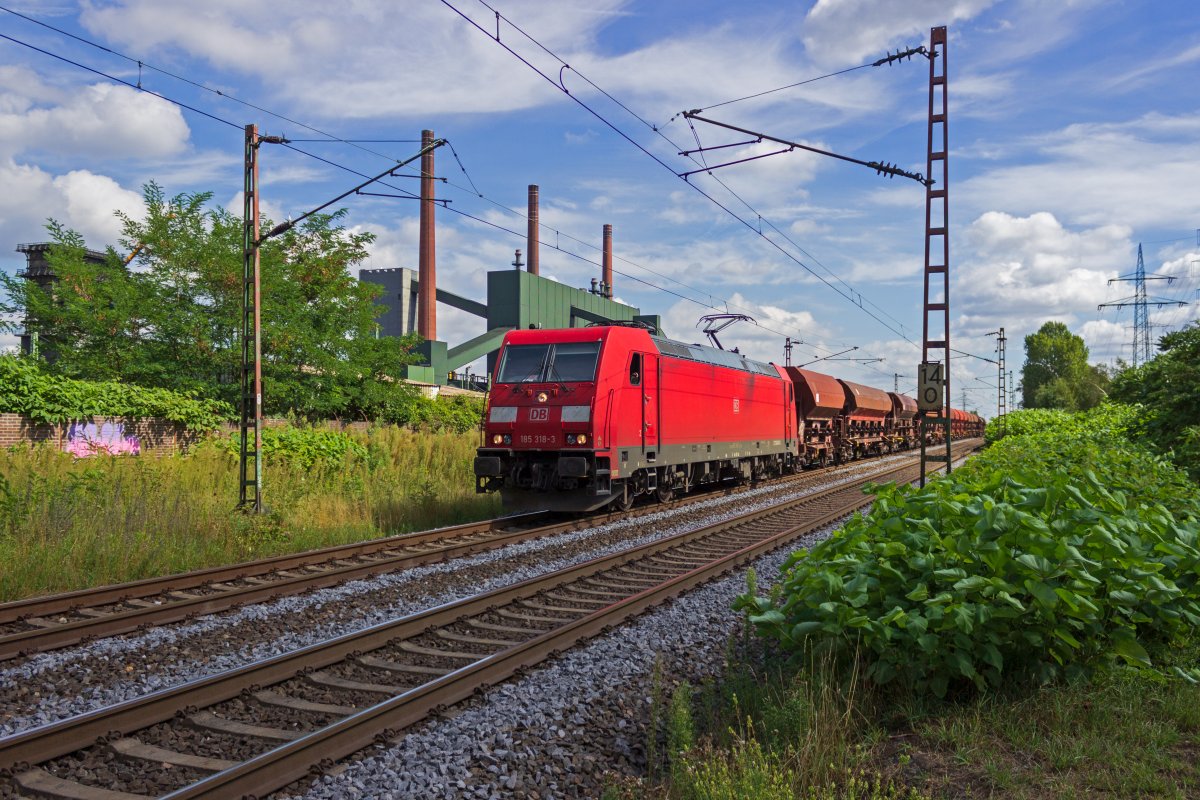 Mit einem Ganzzug aus Selbstentladewagen rollt 185 318 am 18.08.2020 dem Gterbahnhof Bottrop-Sd entgegen.