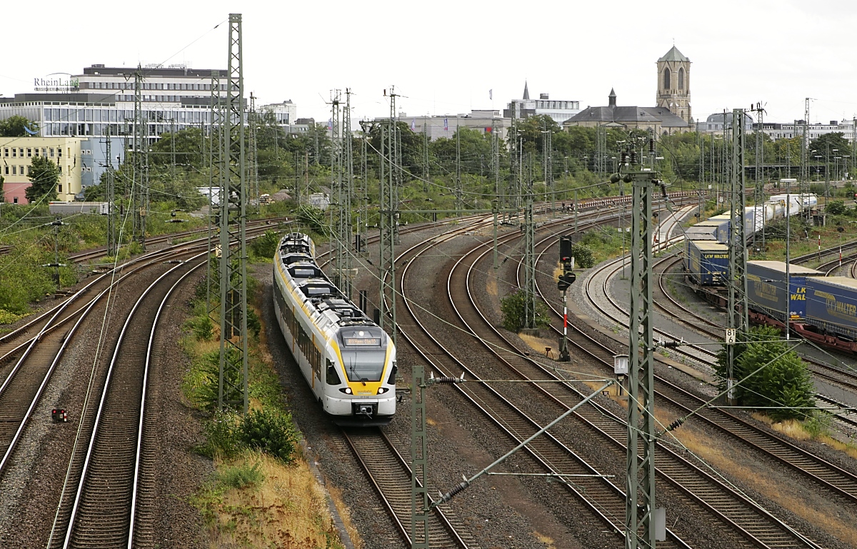 Mit den Eurobahn-Stadler FLIRT und dem RE 13 (Hamm (Westfalen) - Venlo/Niederlande) unterwegs: ET 7.04 verlässt am 10.08.2019 den Neusser Hauptbahnhof in Richtung Düsseldorf, links die Streckengleise von/nach Krefeld, rechts neben dem ET die S-Bahn-Gleise Neuss-Düsseldorf, daneben das Streckengleis Düsseldorf-Neuss und ganz rechts der Rangierbahnhof