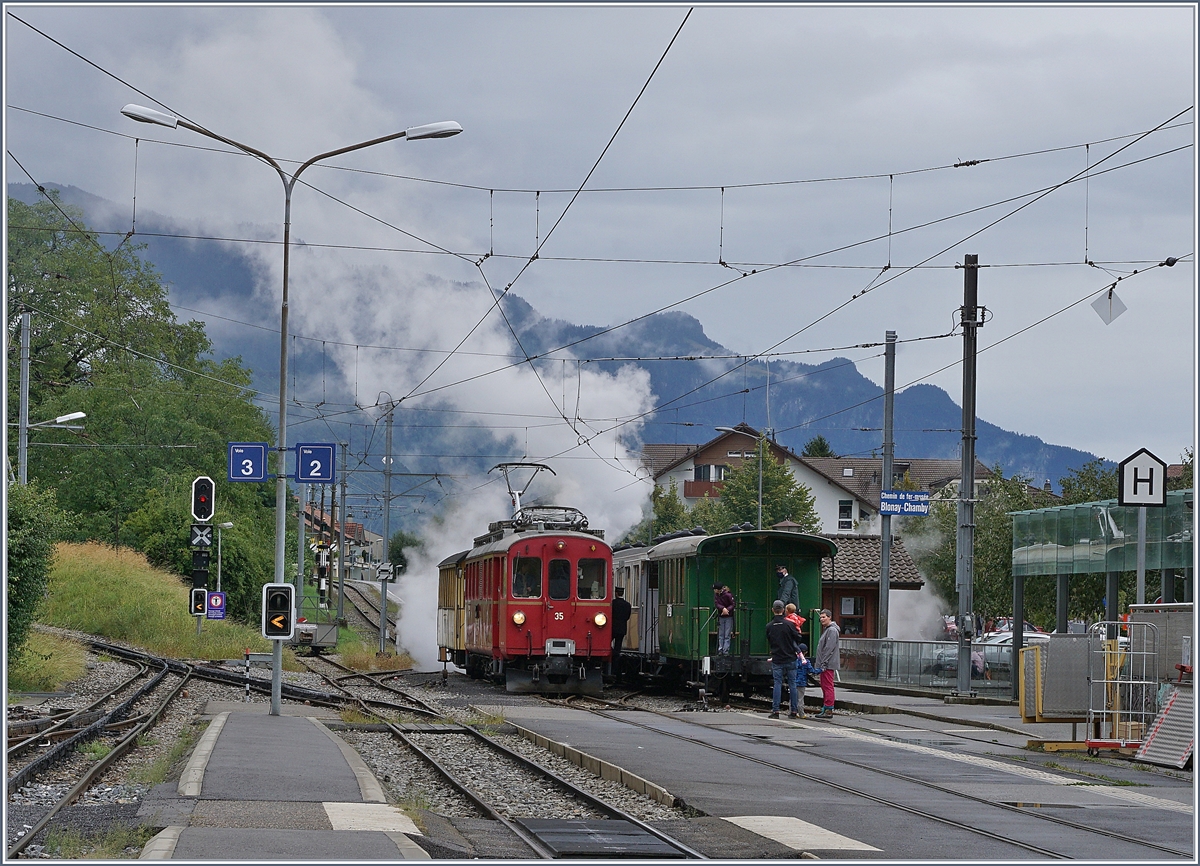 Nach dem Umsetzen der g 2x 2/2 105 ist der RhB ABe 4/4 I 35, der mit seinem Blonay-Chamby  Bernina-Wagen  als Riviera Belle Epoque von Chaulin nach Vevey unterwegs ist bei Halt in Blonay erneut in Dampf gehüllt, aber doch gut zu erkennen. 

30. Aug. 2020