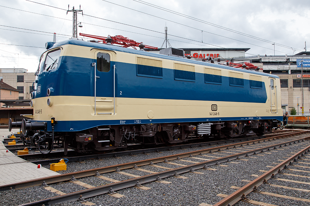 
Nun wieder in der blau/beige Sonderlackierung des  Karlsruher Zuges , diesen trug sie von 1977 bis 2000...........
Die 141 248-5, ex DB E 41 248, wird am 20.08.2016 beim Lokschuppenfest vom Südwestfälischen Eisenbahnmuseums in Siegen vor dem Ringlokschuppen präsentiert. Nach nun nach 16 Jahren in „Verkehrsrot“ wieder  in der Sonderlackierung des  Karlsruher Zuges , so war sie früher auch sehr oft auf der Ruhr-Sieg und der Dill-Strecke zu sehen. Sie war auch die einzige in dieser Versuchslackierung zum Karlsruher Wendezug (grün-beige), diesen trug sie 1977 bis 2000.
 
Die Lok wurde 1963 von Henschel unter der Fabriknummer 30451 gebaut, der elektr. Teil von Brown, Boveri & Cie AG (BBC). Im Jahr 2003 wurde sie z-gestellt, heute ist sie Eigentum vom DB-Museum Nürnberg und eine Leihgabe an das Südwestfälisches Eisembahnmuseum (Bw Siegen).

Von 1977 bis 1995 war der  Knallfrosch“ dem BW Hagen-Eckesey zugeteilt, im Januar 1977 erhielt sie den asymmetrischen S-Bahn-Versuchslack, der der allgemeinen ozeanblau-beigen Farbgebung ähnelt. Die Lok sollte immer mit der gleichen Seite an einem mit blauen Fensterband umgerüsteten Versuchszug der BD Essen aus umgebauten Silberlingwagen für den S-Bahn-Verkehr am Zug hängen, damit Lok und Wagen farblich harmonierten. Dieser Zug, der sogenannte „Karlsruher Zug“, war der Prototyp für die bis heute zahlreich eingesetzten S-Bahn-Züge, gebildet aus Lokomotiven der Baureihen 111 bzw. 143 und drei bis fünf x-Wagen.