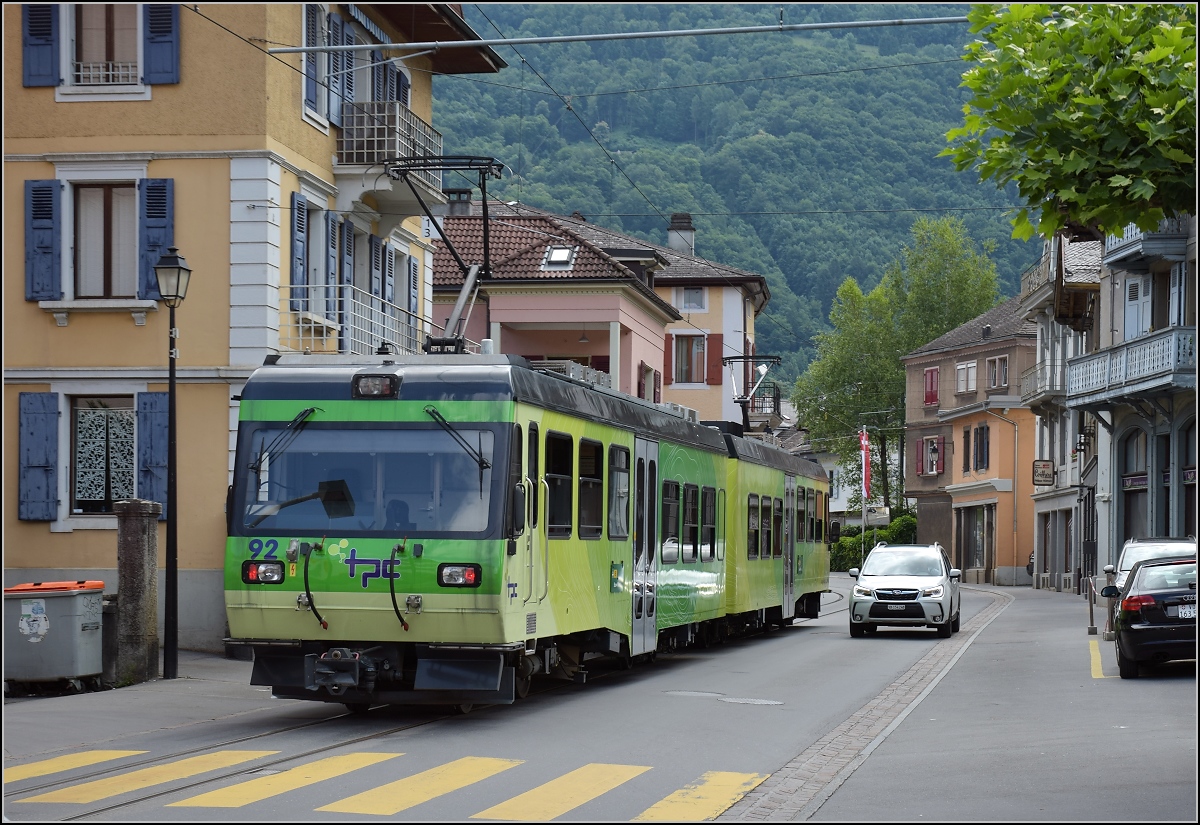 Ortsdurchfahrt in Bex. Der TPC-Triebwagen 92 nutzt die falsche Straßenseite, so wird der geneigte Autofahrer ohne Chance auf Widerstand zum englischen Autofahrer. Juli 2017.