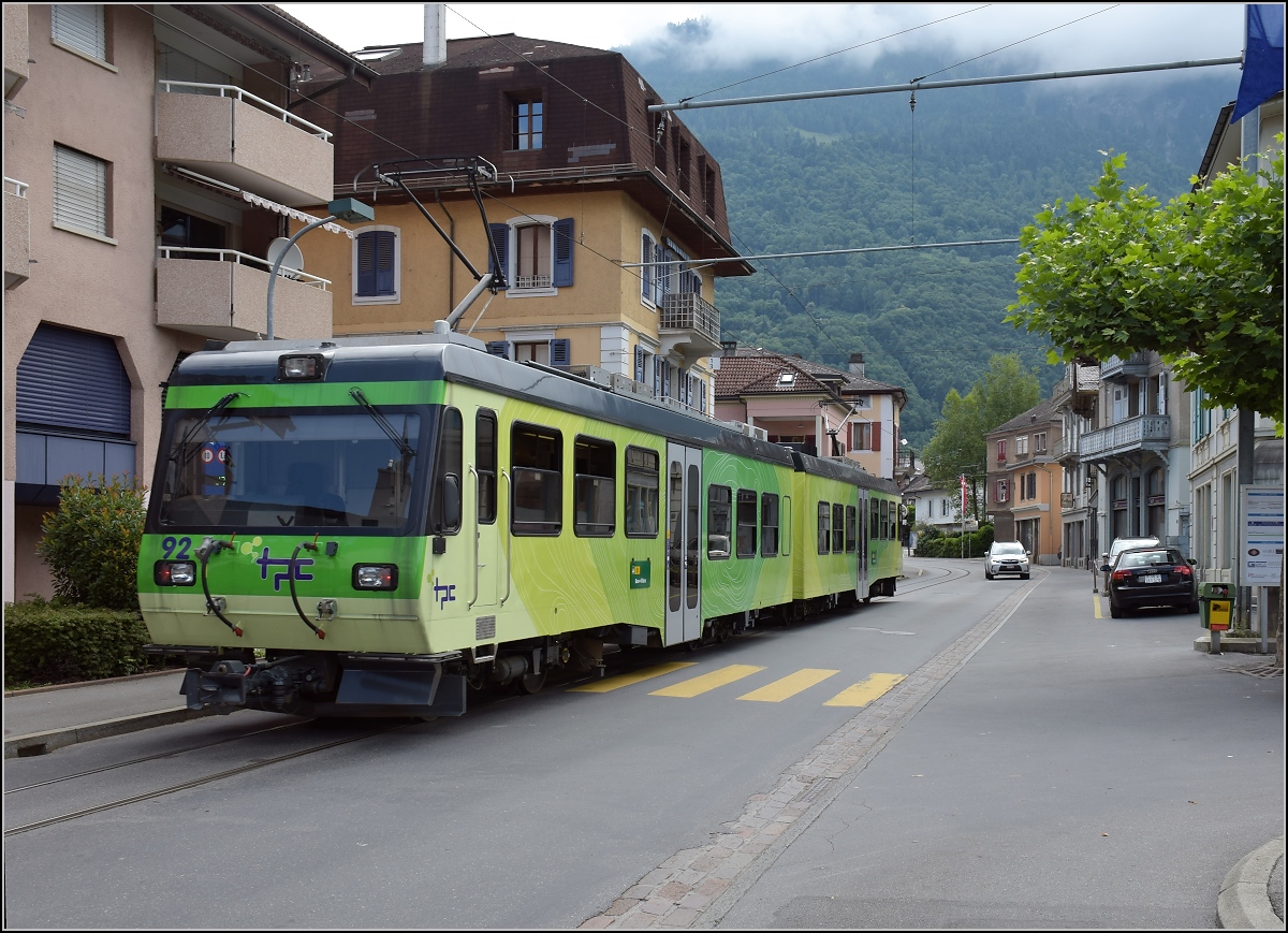 Ortsdurchfahrt in Bex. Der TPC-Triebwagen 92 nutzt die falsche Straßenseite, so wird der geneigte Autofahrer ohne Chance auf Widerstand zum englischen Autofahrer. Juli 2017.