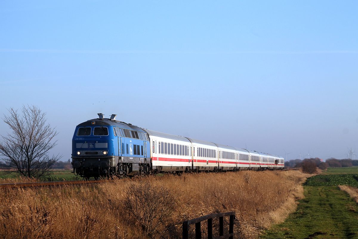 PRESS 218 454 (218 056) passiert mit ihrem 9-Wagen IC 2072 unter Höllenlärm den Bü Triangel auf dem Weg nach Westerland 19.12.2020