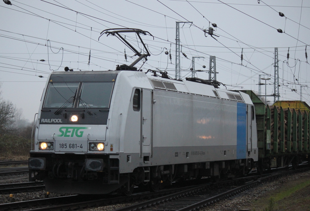 Railpool 185 681-4 SETG  mit  Holzzug von Rostock-Bramow nach Stendal-Niedergrne bei der Durchfahrt im Rostocker Hbf.06.12.2014