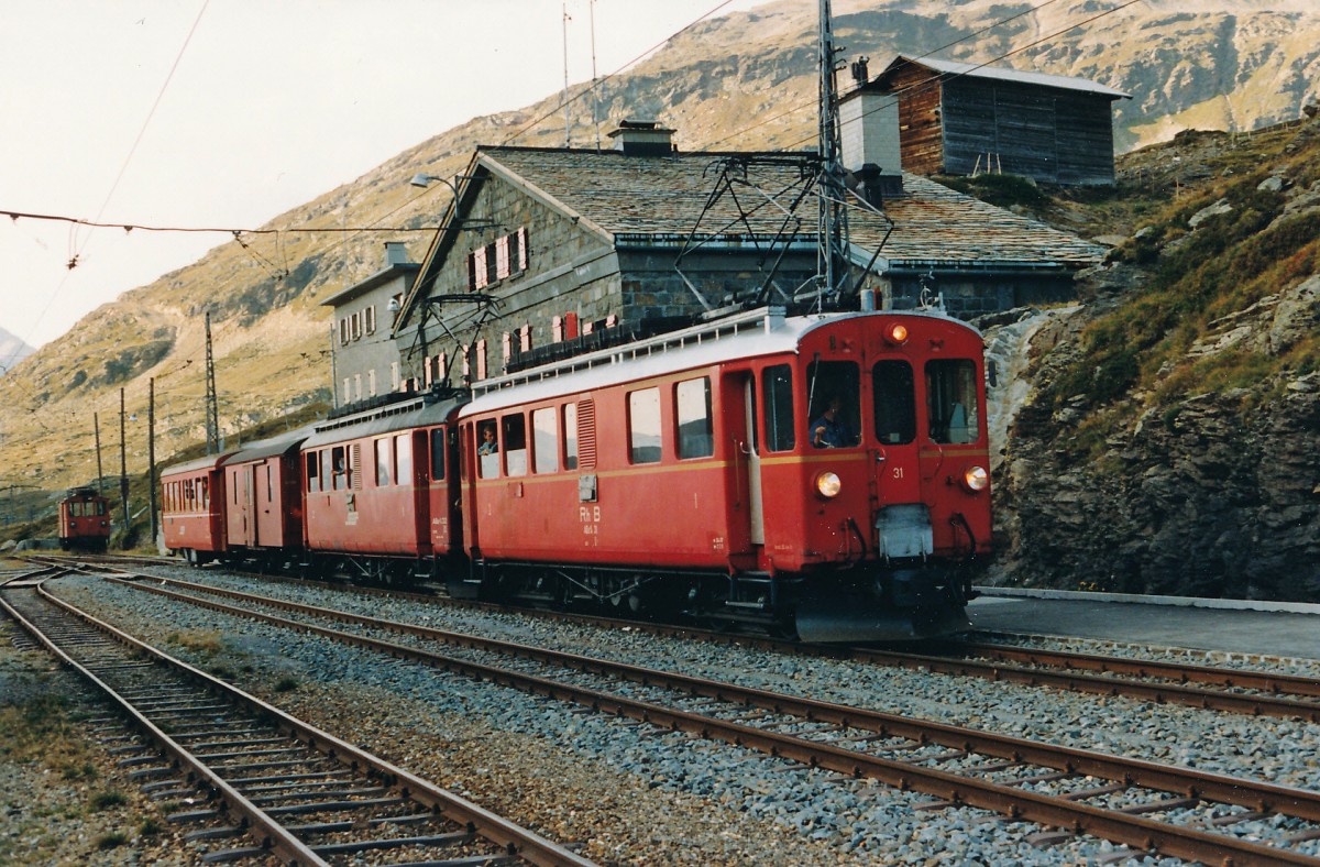 RhB: Am 7. Oktober 1987 wurde der erste Planzug St. Moritz-Tirano mit den ABe 4/4 31 und ABe 4/4 32 geführt. Da es an diesem Tag keine Güterlast zu befördern gab, wurde der Bahnhof Ospizo Bernina vorzeitig erreicht. Damit die Fahrt planmässig fortgesetzt werden konnte, gönnte sich das Bahnpersonal eine Pause im Restaurant, die der Bahnfotograf als Fotohalt nutzte. Auch reichte die Zeit noch für einen Schwatz mit dem freundlichen Lokführer. Das waren noch Zeiten.......
Foto: Walter Ruetsch   