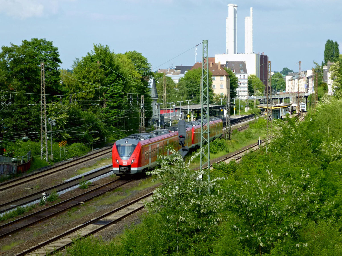 S-Bahn im Großstadtdschungel: Vor der Kulisse des Heizkraftwerks und umgeben vom frühlingshaften Grün im Bereich des Bahnhofs in Wuppertal-Barmen präsentiert sich die S8 am 11.5.18.