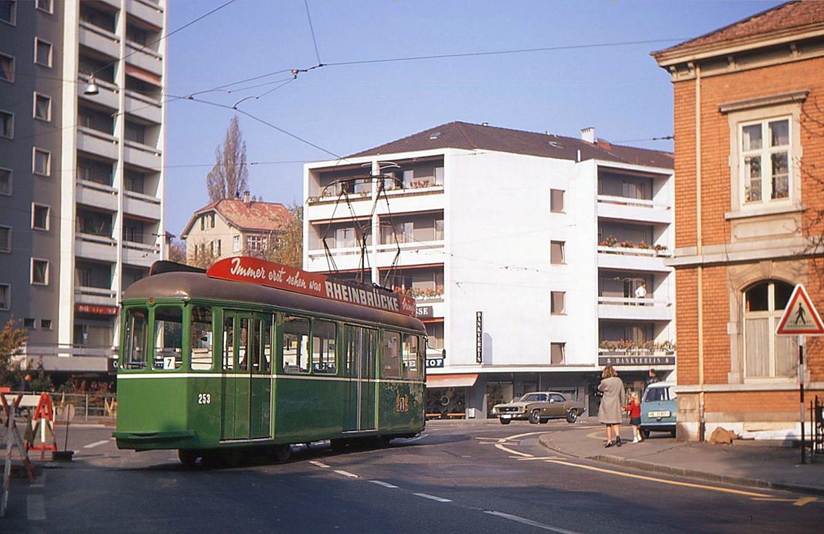 Schon 1952 gab es in der Schweiz ein Niederflurtram! Die drei ultraleichten Be 2/4 251-253 (urspr. 601-603) der BVB Basel hatten hinten ein Mini-Drehgestell (von SWP), so dass die Einstiegshöhe nur 415 mm betrug. Der Raddurchmesser war 420 mm. Nur das vordere Drehgestell war angetrieben, und der Boden stieg deshalb im Wageninneren auf 840 mm an. Die Wagen waren kürzer als die regulären Standardwagen, so war auch die Verjüngung hinten und vorn weniger stark; die Türen waren somit nicht ganz, aber fast bündig mit der Aussenwand, und es brauchte auch keine Klapptrittbretter. 1956/57 wurden ähnliche Wagen nach Rotterdam geliefert, doch nach einem Referendum war der Serienbau für die BVB nicht mehr möglich. Nicht sehr beliebt war die geringe Anzahl Sitzplätze (nur Einersitze), und in meiner Erinnerung rumpelten die Wagen stark wegen des kleinen Drehgestells hinten. Bis 1966 waren sie der damaligen Ringlinie 2 zugeteilt bis zu ihrer teilweisen Stilllegung, danach leisteten sie im wesentlichen nur noch abends und an Wochenenden Dienst auf der Linie 7 nach Binningen (plus vereinzelt Einsatzkurse E am Mittag). 1970 wurden sie für den kondukteurlosen Betrieb umgerüstet, 1972 abgestellt und 1978 abgebrochen. Schade um diese Pionierfahrzeuge, die mit ihrem Niederflurkonzept ihrer Zeit weit voraus waren! Im Bild Wagen 253 in Binnigen; ganz schwach ist das hintere Mini-Drehgestell erkennbar. 31.Oktober 1969  