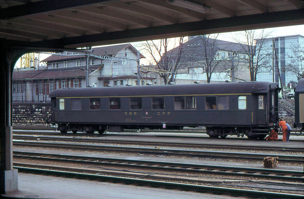 Schwere SBB-RIC Personenwagen erster Klasse überlebten bis in die Achziger Jahre als Begleitwagen für Güterzüge, in erster Linie wohl für die  rollende Landstrasse . Hier steht Db 60 85 99-29 463 in Basel SBB, mit Problemen bei der Heizungskupplung. Die beiden einstigen Erstklass-Abteile aus der Zeit des Dreiklassensystems sind an den Doppelfenstern deutlich erkennbar. 11.Februar 1981 