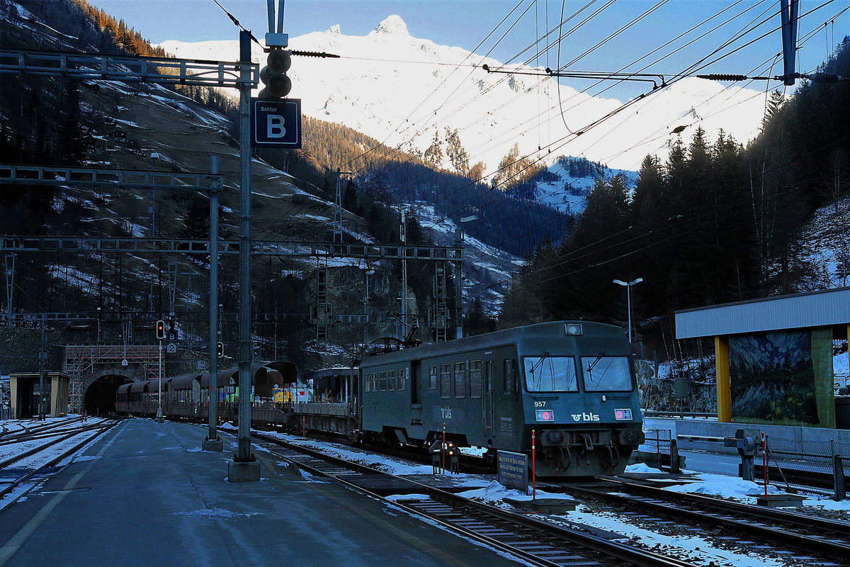 Steuerwagen der Autozüge durch den Lötschberg-Scheiteltunnel: Während in Goppenstein die Alpen schneeweiss im Sonnenlicht strahlen, verzieht sich im Dunkeln der Steuerwagen BDt 50 85 80-35 957 (Serie 956-959 von 1991) in den Lötschbergtunnel. 7.Januar 2021