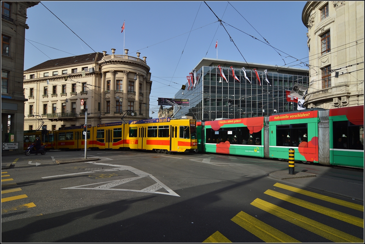 Straßenbahn Basel. Viel Verkehr an den Haltestellen Bankverein. Entgegen kommt ein Wagen von Schindler aus den 90ern mit nachträglich eingehängtem Niederflur Mittelteil, Spitzname Guggumere. Februar 2014.