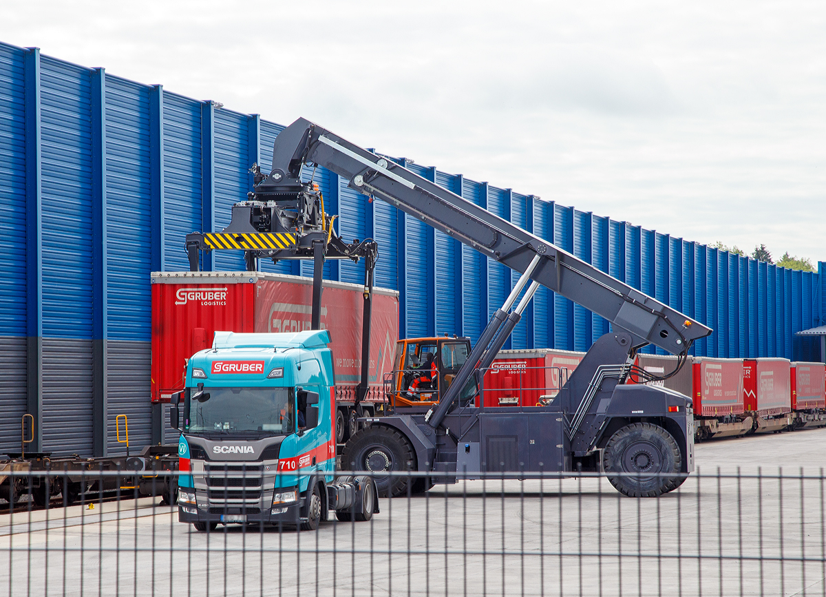 
Südwestfalen Container-Terminal GmbH (SWCT), Kreuztal Ubf, den 31.05.2019:
Die Entladung der Gelenk-Taschenwagen der Gattung Sdggmrs (Typ T3000e).  Die Sattelauflieger (Sattelanhängern) werden nach und nach mittels Reachstacker bzw. Greifstapler aus den Gelenk-Taschenwagen gehoben und sofort an die Sattelzugmaschine angehangen.
