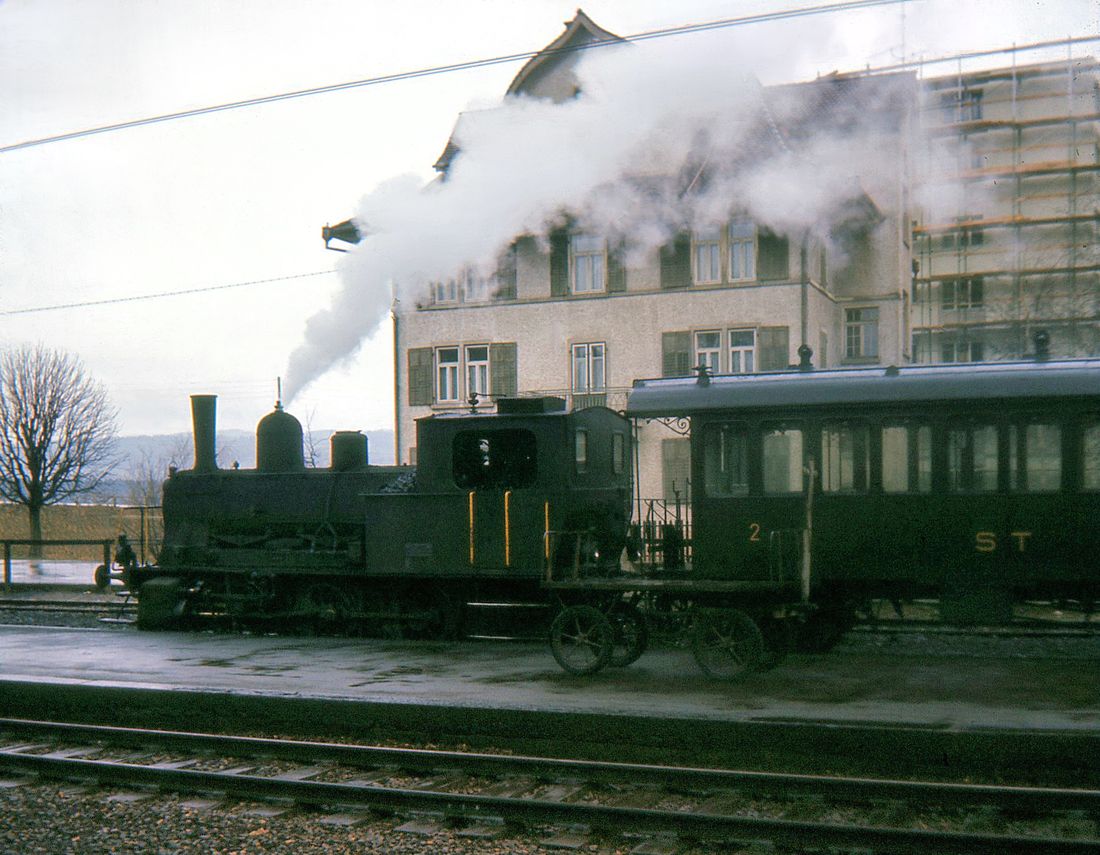 Sursee Triengen Bahn (Regelbetrieb): Die kleine Lok zischt freudig unmittelbar vor der Abfahrt. Sursee, 21.März 1965. 