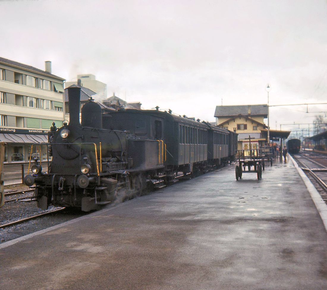 Sursee Triengen Bahn (Regelbetrieb): Diese knapp 9 km lange Strecke stellte den Regelbetrieb am 26.September 1971 ein. Hier wartet ein fahrplanmssiger Zug in Sursee auf Abfahrt. Der Zug besteht aus der ehemaligen SBB-Dampflok ST 5, einem Erst- und Zweitklasswagen, einem Zweitklasswagen, und einem Gepckwagen. 21.Mrz 1965. 