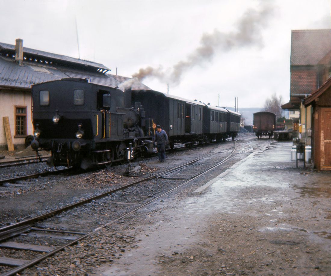 Sursee Triengen Bahn (Regelbetrieb): Friedlich wartet der Zug in Triengen auf die Rückfahrt nach Sursee. Der Gepäckwagen transportiert die lokale Milch. 21.März 1965.