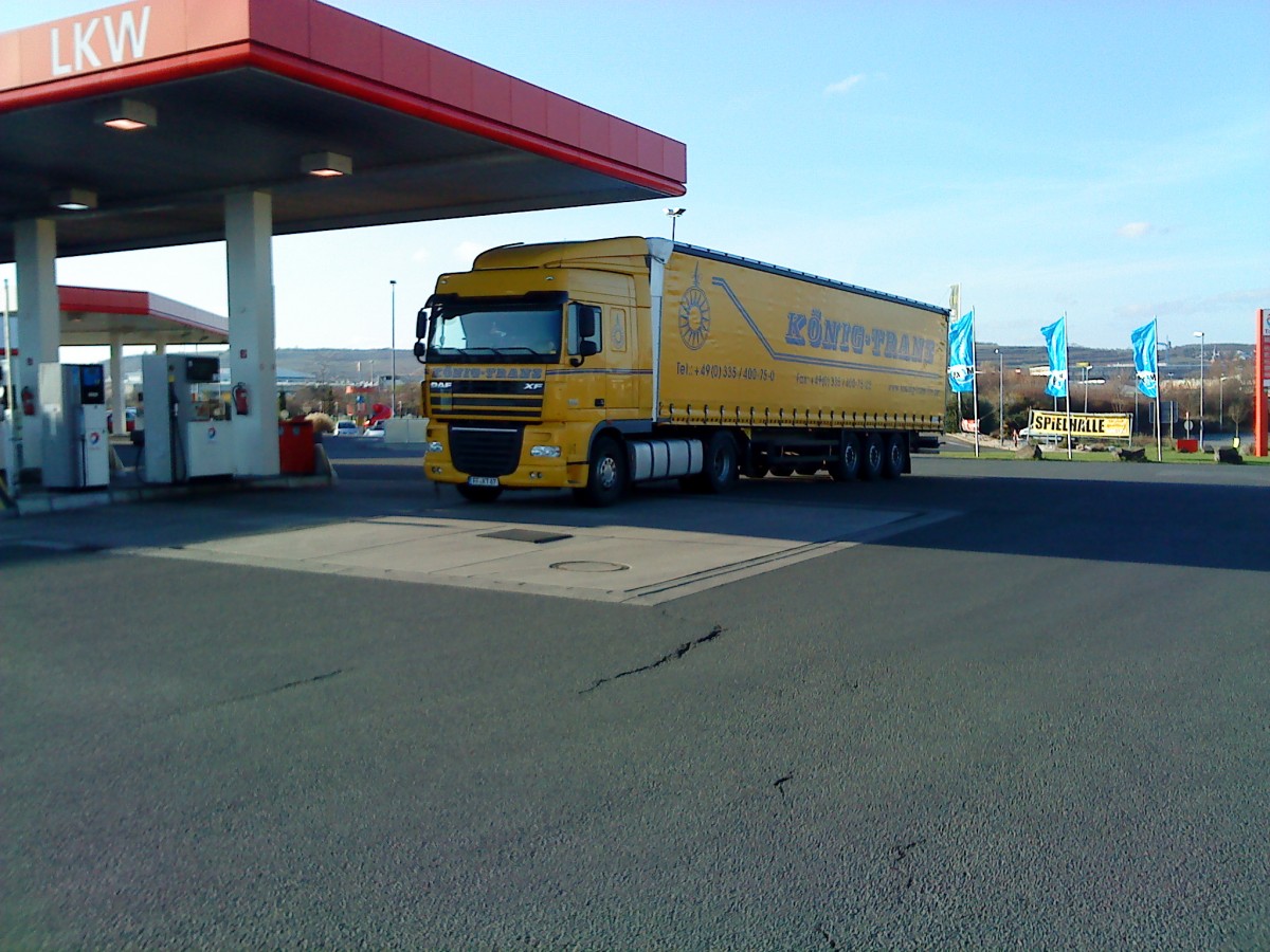 SZM DAF XF mit Pritsche-Planen-Auflieger der Spedition Knig-Trans auf dem Weg zur Tankstelle auf dem Autohof in Grnstadt am 02.12.2013