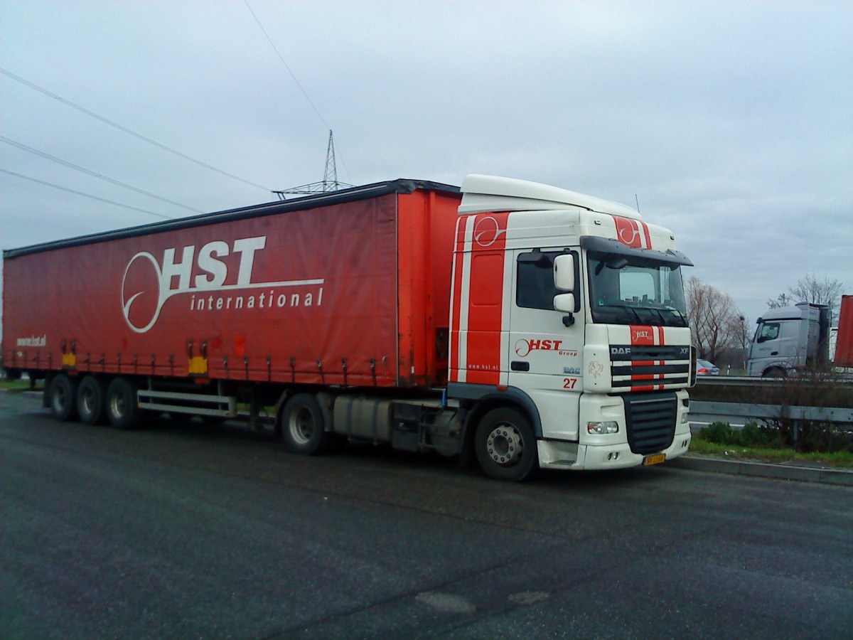 SZM DAF XF mit Pritsche-Planen-Auflieger der Spedition HST International gesehen auf dem Parkplatz der Raststtte Dannstadt an der A 61 am 16.01.2014