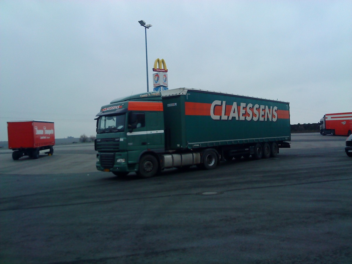 SZM DAF XF mit Pritsche-Planen-Auflieger der Spedition Claessens gesehen auf dem Parkplatz am Autohof Grnstadt am 03.02.2014