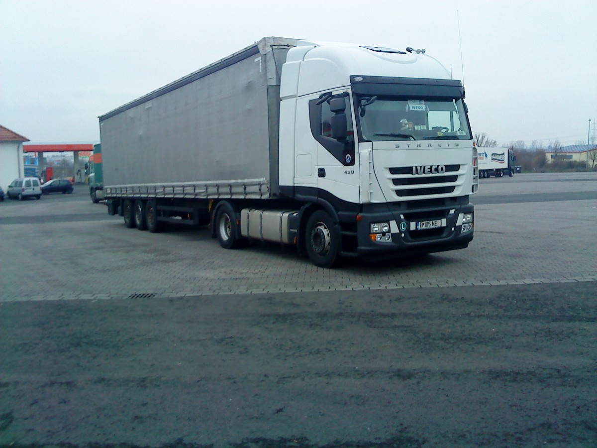 SZM IVECO Stralis 450 mit Pritsche-Planen-Auflieger gesehen auf dem Parkplatz am Autohof Grnstadt am 03.02.2014