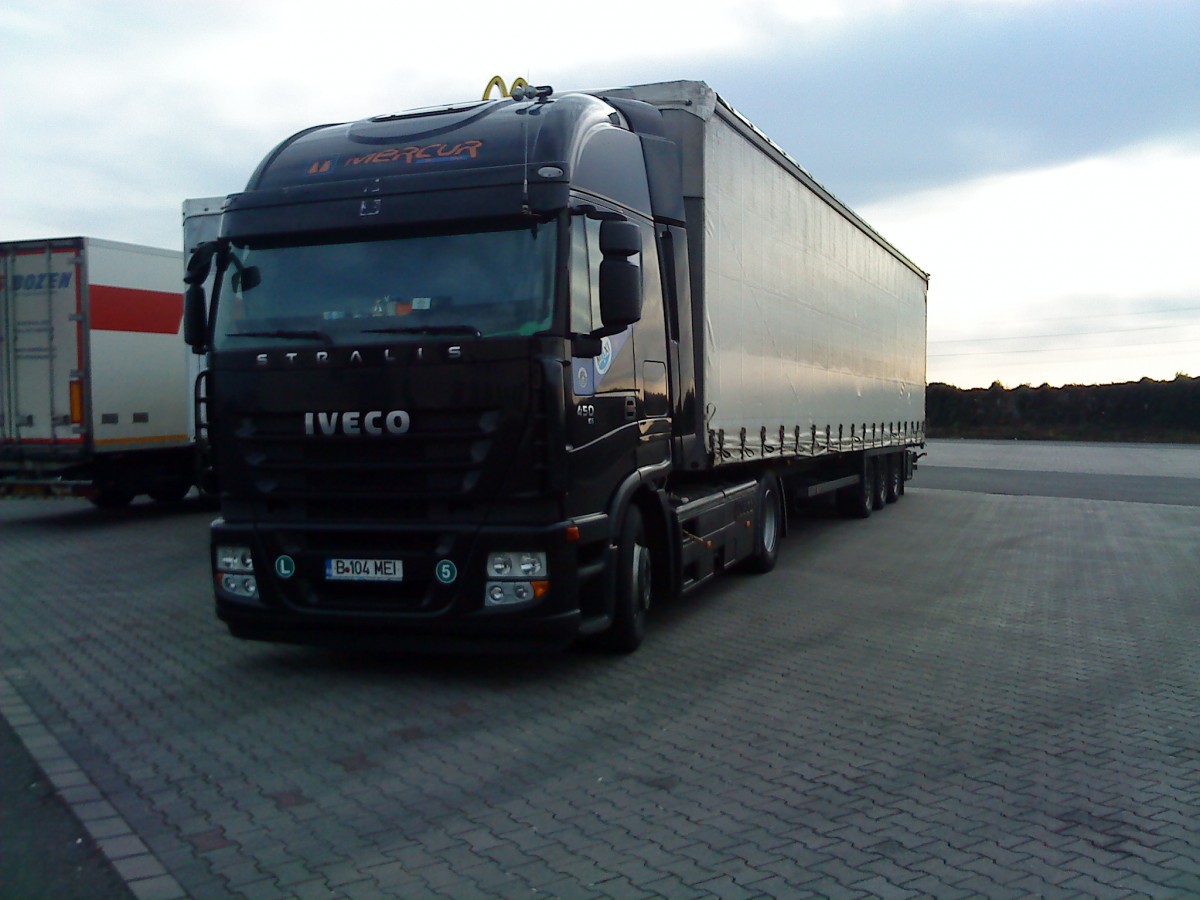 SZM IVECO Stralis mit Pritsche-Planen-Auflieger gesehen auf dem Autohof in Grnstadt am 19.02.2014