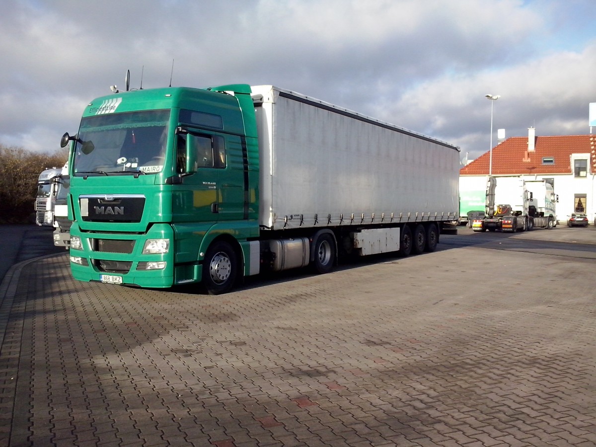 SZM MAN TGX 18.440 mit Pritsche-Planen-Auflieger gesehen auf dem Autohof in Grnstadt am 13.02.2014