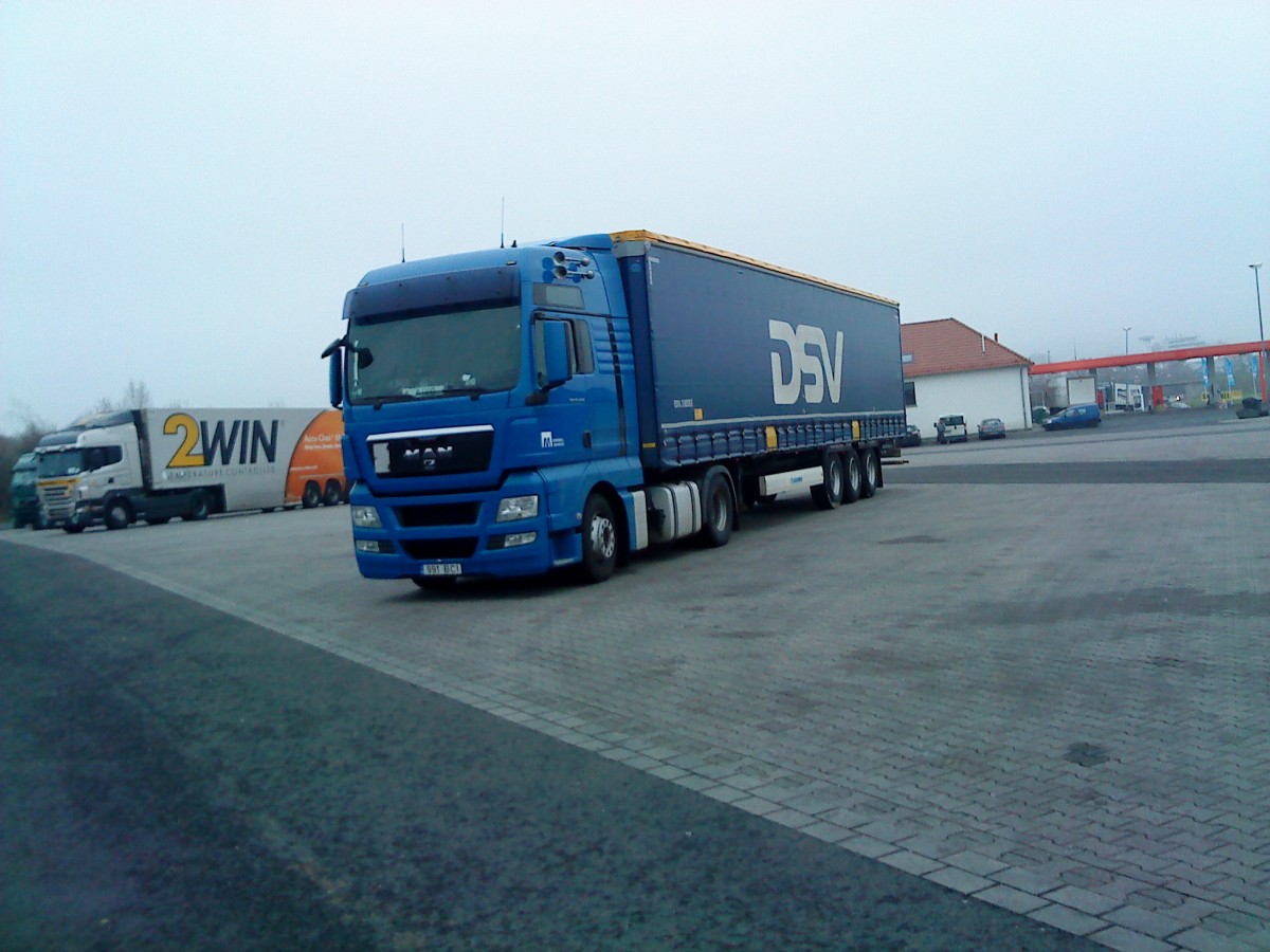 SZM MAN TGX mit Pritsche-Planen-Auflieger der Spedition DSV aus Dnemark auf dem Autohof in Grnstadt am 12.12.2013