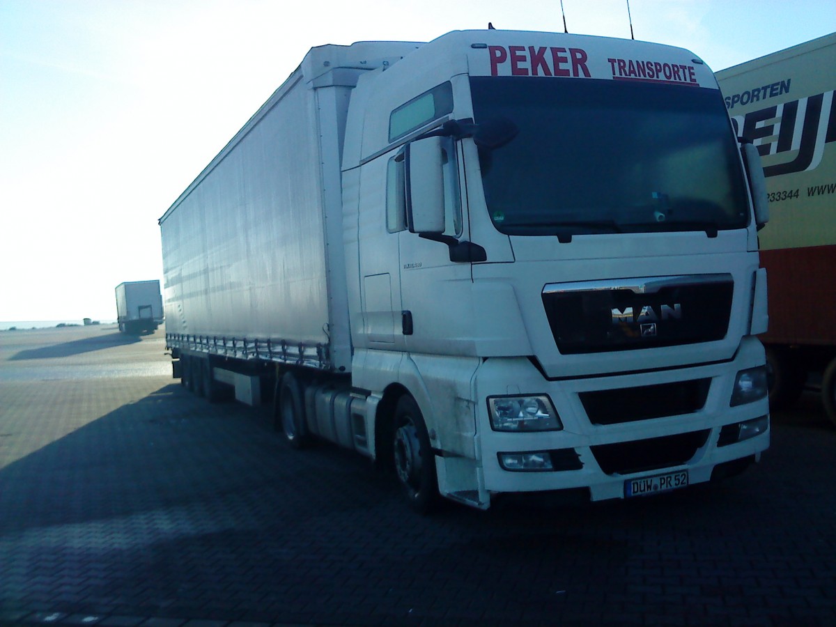 SZM MAN TGX mit Pritsche-Planen-Auflieger der Spedition PEKER Grnstadt auf dem Autohof in Grnstadt am 30.12.2013