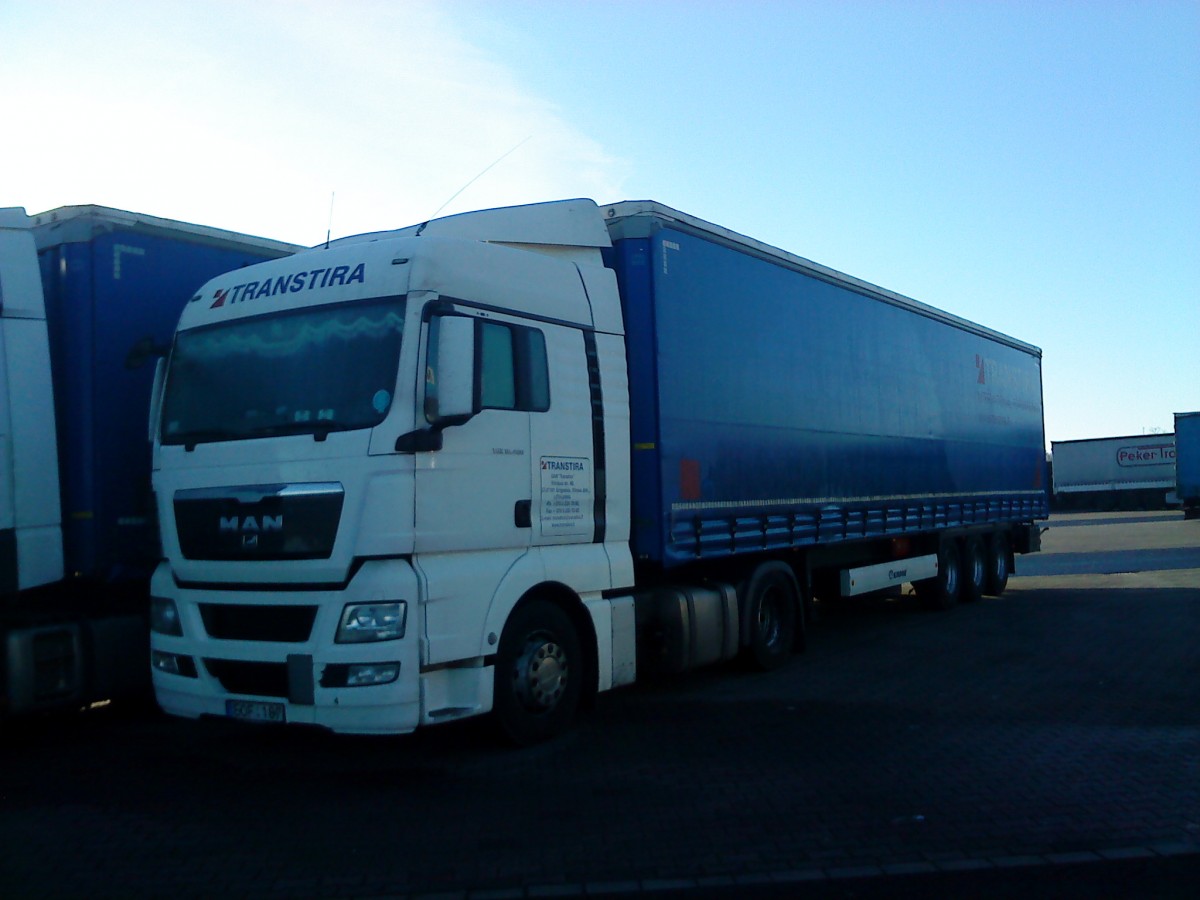 SZM MAN TGX mit Pritsche-Planen-Auflieger der Spedition Transtira auf dem Autohof in Grnstadt am 30.12.2013