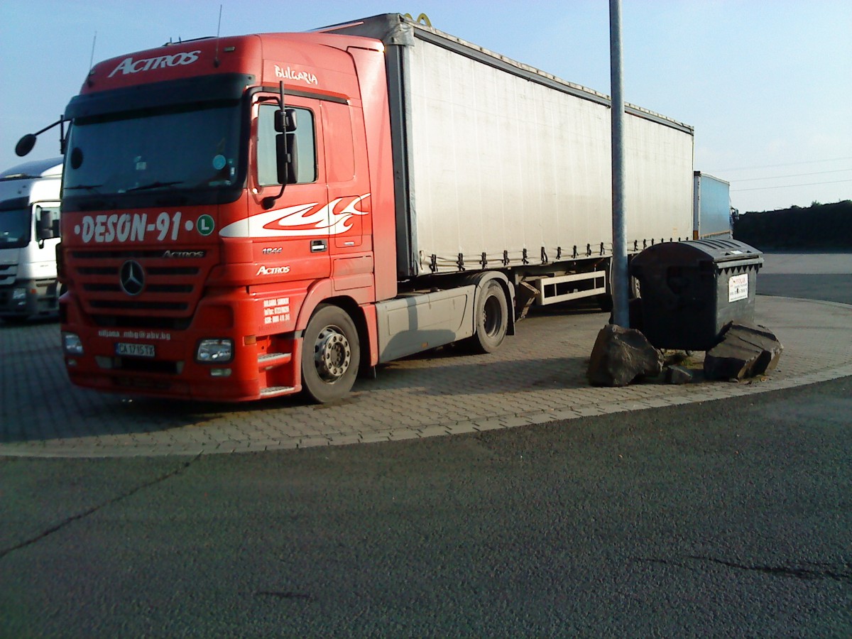 SZM Mercedes-Benz Actros 1844 mit Pritsche-Planen-Auflieger auf dem Autohof in Grnstadt am 03.12.2013