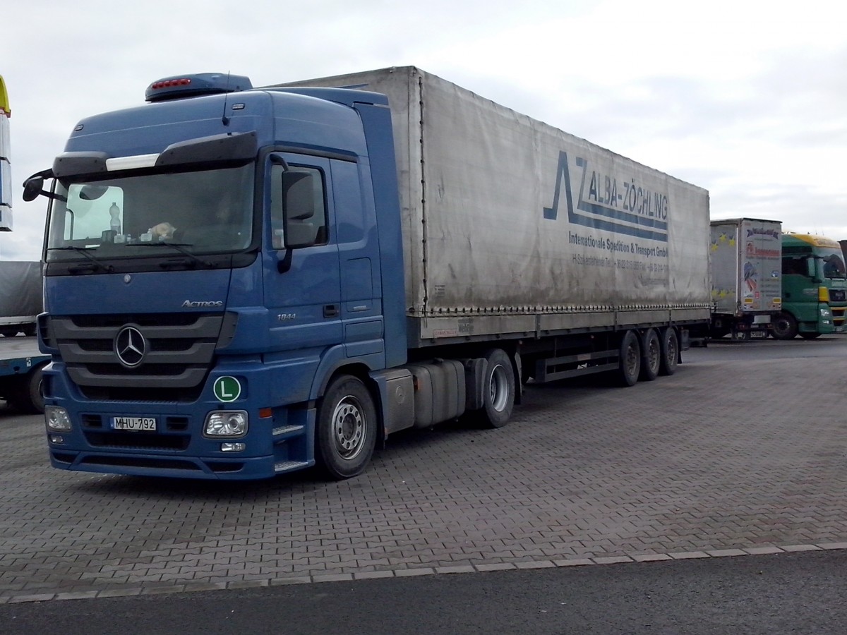 SZM Mercedes-Benz Actros 1844 mit Pritsche-Planen-Auflieger der Spedition Alba-Zchling gesehen auf dem Autohof in Grnstadt am 11.02.2014