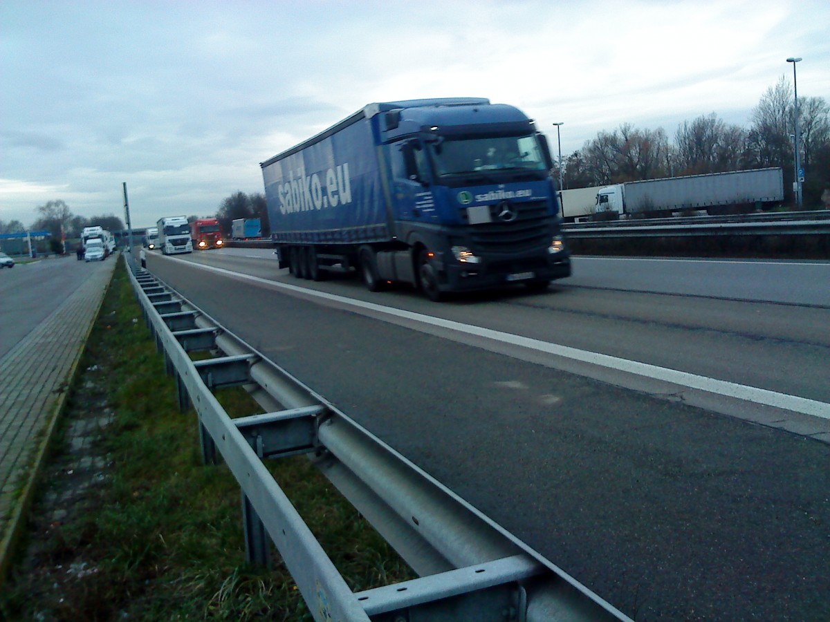 SZM Mercedes-Benz Actros mit Pritsche-Planen-Auflieger der Spedition Sabiko gesehen auf der A 61, Hhe Raststtte Dannstadt, am 16.01.2014