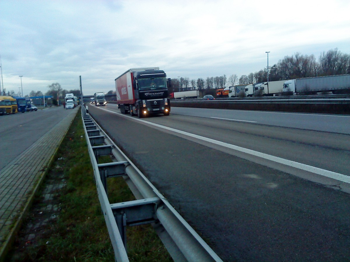 SZM Renault Magnum mit Pritsche-Planen-Auflieger gesehen auf der A 61, Höhe Raststätte Dannstadt, am 16.01.2014