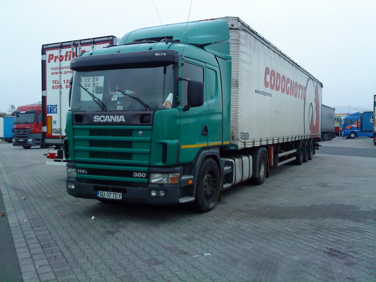 SZM SCANIA 114 L 380 mit Pritsche-Planen-Auflieger auf dem Autohof in Grnstadt am 20.11.2013