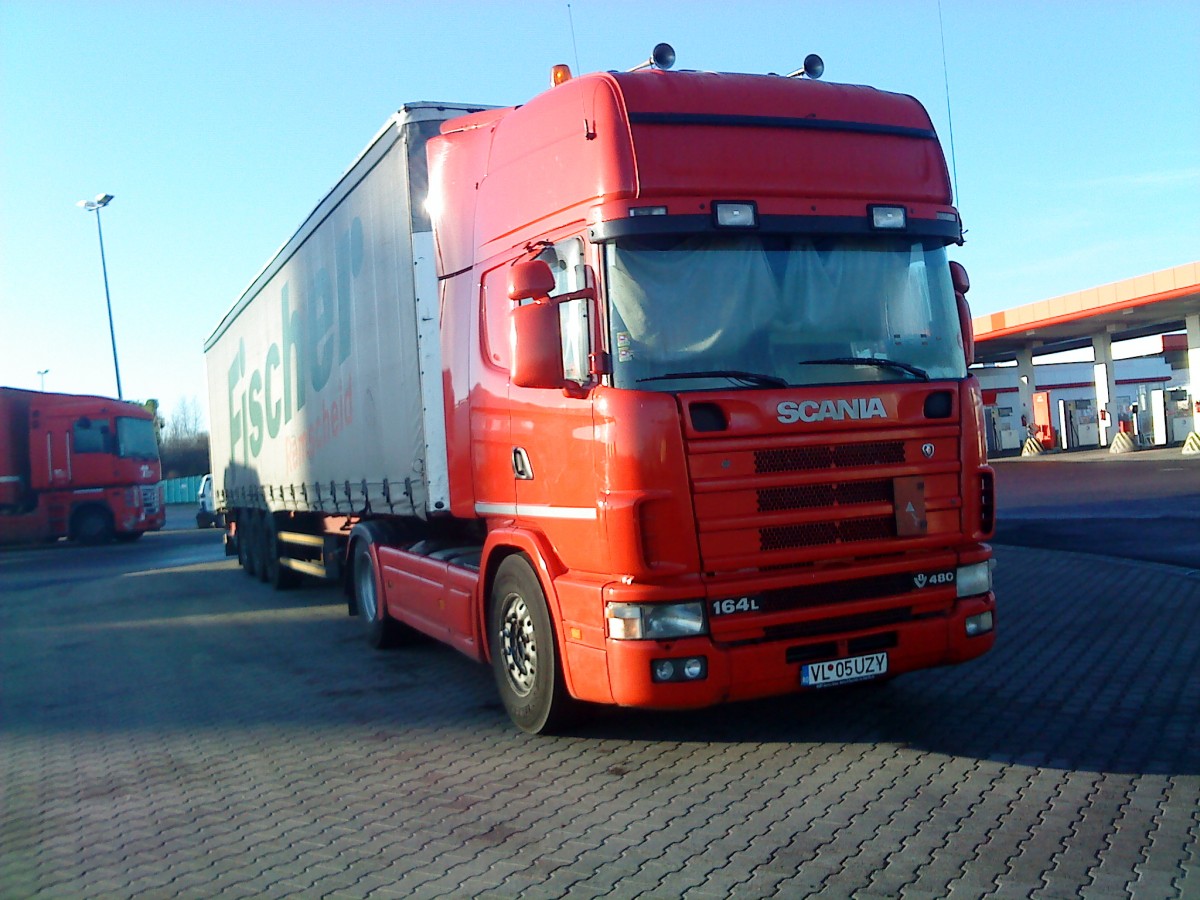 SZM SCANIA L 164 mit Pritsche-Planen-Auflieger der Spedition Fischer auf dem Autohof in Grnstadt am 30.12.2013