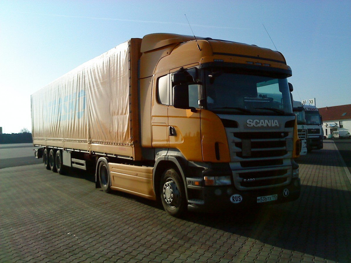 SZM SCANIA R 420 mit Pritsche-Planen-Auflieger auf dem Autohof in Grnstadt am 11.12.2013