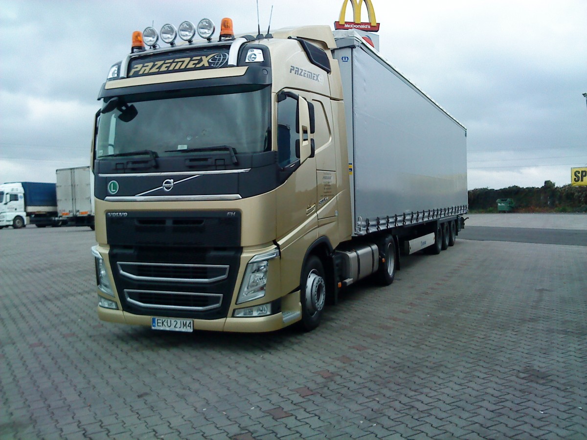 SZM Volvo FH - EuroNorm6 - mit Pritsche-Planen-Auflieger auf dem Autohof in Grnstadt am 05.12.2013