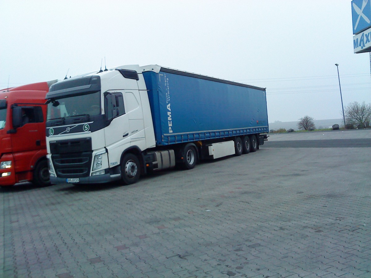 SZM Volvo FH mit Pritsche-Planen-Auflieger der Vermietungsgesellschaft PEMA auf dem Autohof in Grnstadt am 12.12.2013