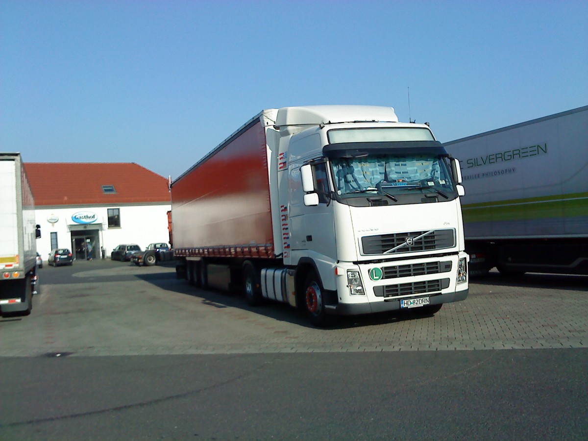 SZM VOLVO FH mit Pritsche-Planen-Auflieger gesehen auf dem Autohof in Grnstadt am 10.03.2014